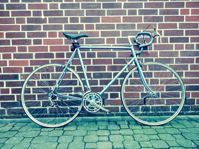 Road bike leaning against a red brick wall