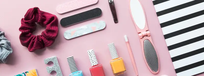Nail files, polish and a scrunchie on a pink table
