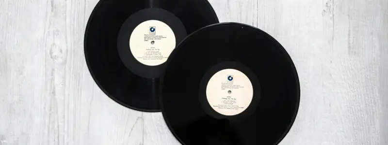 Two vinyl records on a white wooden table